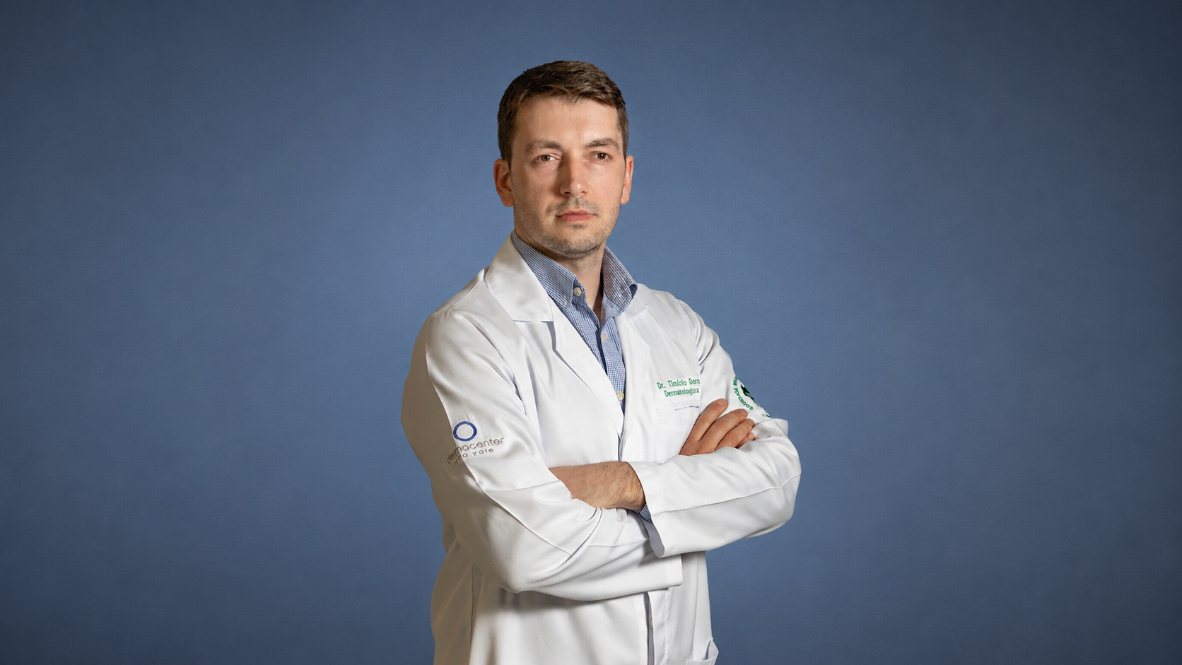 Retrato do Dr. Timótio Dorn, dermatologista, vestindo jaleco branco e posando com os braços cruzados.